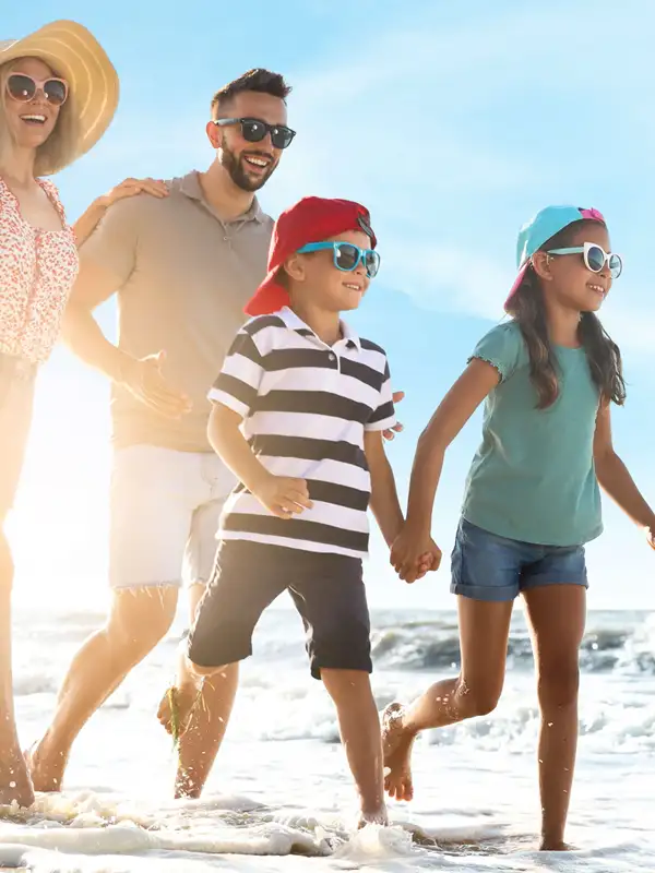 Familie mit zwei Kindern am Strand an einem schönen Sommertag.